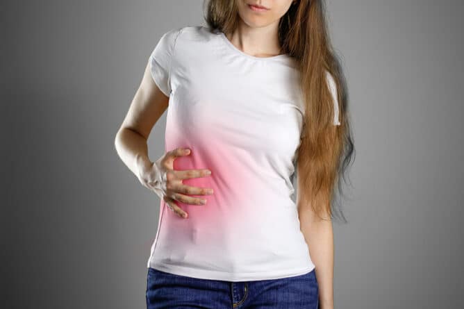 A woman holds the liver. Pain in the abdomen. Cirrhosis of the liver. Sore point highlighted in red. Closeup. Isolated.